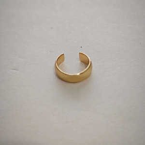 Macro detail of gold vintage non-pierced ear cuff with a matte metallic finish