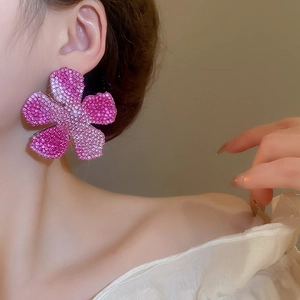 Macro side view of elegant flower earrings with gradient pink rhinestones on a model