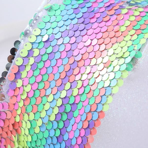 Dettaglio delle paillettes arcobaleno scintillanti sulla borsa a sirena per bambina in pastello
