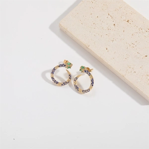 Detailed close-up of snake earrings with blue leopard enamel and green gemstone eyes