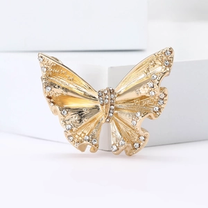 Elegant gold butterfly brooch with crystal inlay on a minimalist white background