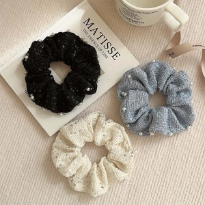 Three-piece set of woven fabric scrunchies with pearls in black, light blue, and beige colors