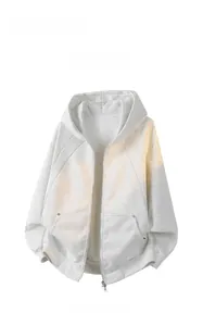 Detail eines hellgrauen Oversize-Kapuzenpullovers mit Metallreißverschluss und Taschen