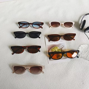 Chic square and oval sunglasses in multiple colors on a textured neutral background