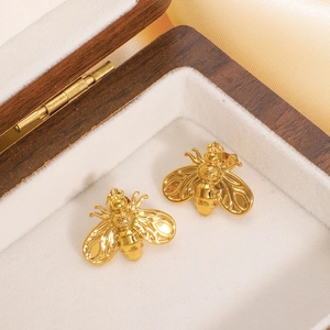 Polished 18k gold plated stainless steel bee stud earrings on a velvet jewelry box