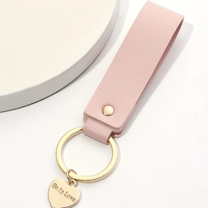 Pink leather keychain with golden heart pendant engraved with Life is Love
