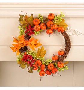 Detail of autumn wreath with mini pumpkins, red berries, and maple leaves on a white mantle