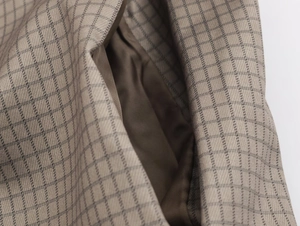 Macro shot of coffee brown checkered woven fabric detail with silk-like lining and pocket