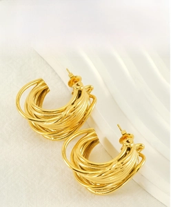 Detailed view of layered gold multi-line irregular hoop earrings on a white background