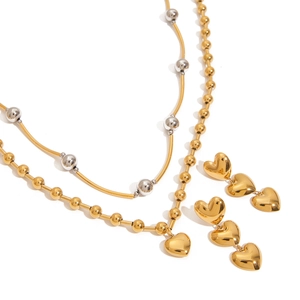 Ensemble élégant collier et boucles d'oreilles cœur en or et argent sur fond blanc