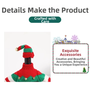 Detail of Christmas wine bottle cover with knitted sweater and hat featuring a gold bell