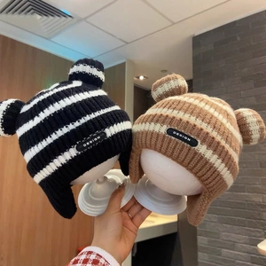 Detailed knit texture of baby earflap hats with striped pattern and cute round ears