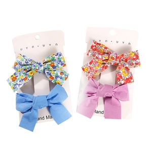 Floral fabric bow hair clips set for girls including blue and pink patterns on white background