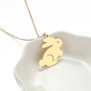 Fashionable gold rabbit silhouette pendant necklace on white plate for elegant women