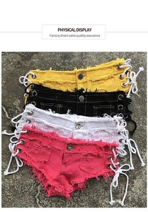 Dettaglio degli shorts in denim a vita bassa con orli sfrangiati e lacci laterali