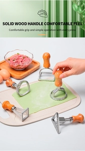 Macro view of dumpling cutters with solid wood handles on dough with ingredients