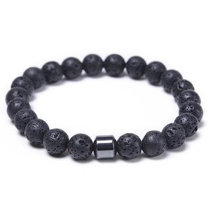 Macro shot of 8mm black lava rock beads showing detailed porous texture on elastic bracelet