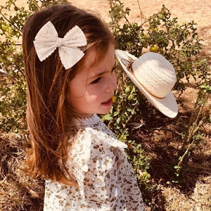 Girl wearing cream lace bow hair clip in a vintage style, outdoor natural setting