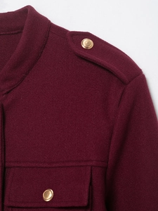 Détail de veste bordeaux en laine mélangée avec texture et boutons en métal doré
