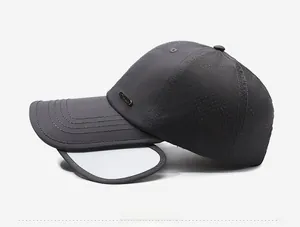 Dettaglio del cappellino sportivo grigio scuro con rete traspirante e logo in metallo