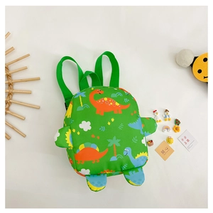 Detail of green kids backpack with cartoon dinosaur pattern and padded shoulder straps