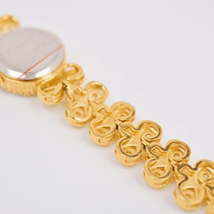 Macro view of gold vintage watch strap with cutout links and silver stainless steel caseback