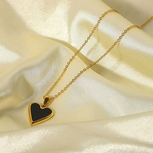 Minimalist 18K gold plated heart pendant necklace with black onyx on silk background
