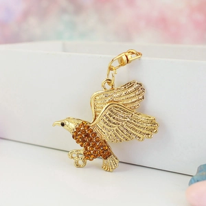 Makroaufnahme von goldener Adler-Schlüsselanhänger mit Bernstein-Steinen und Details