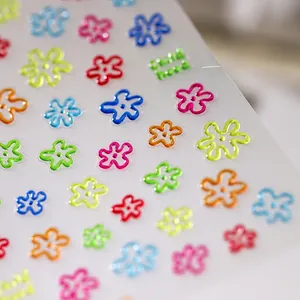 Macro shot of 3D embossed floral nail stickers with colorful flowers and Childhood text