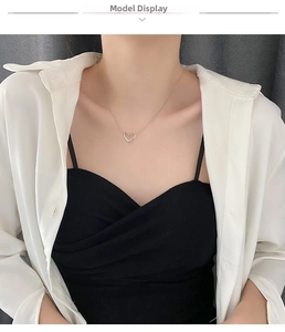 Model wearing a delicate silver hollow heart necklace made of durable titanium steel
