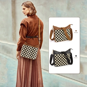Detail of checkered pattern texture and golden hardware on crossbody messenger bag