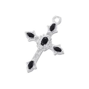 Close-up of silver cross pendant with black oval gemstone and sparkling clear crystals