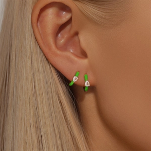 Detailed close-up of fluorescent green enamel earrings with drop-shaped zircon