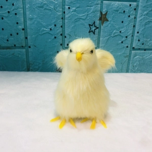 Realistic small yellow plush chick toy on white fuzzy mat with starry blue background