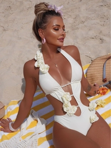 White cutout monokini with 3D floral accents and pearl chain details for summer beach