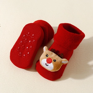 Detail of red Christmas baby socks with 3D reindeer decor and anti-slip silicone grippers