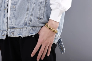 Close-up of golden stainless steel double-layered Cuban chain bracelet on male wrist