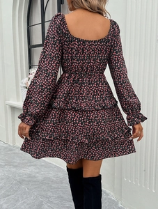 Detail view of the smocked waist and tiered ruffle hem on a floral long-sleeve dress