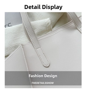 Detailed close-up of reinforced double stitching on off-white faux leather tote bag