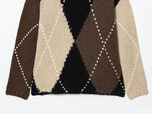 Detail of argyle knit sweater with thick brown, black, and beige textured wool blend fabric