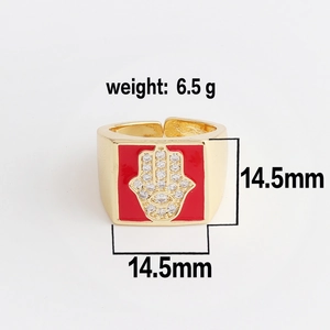Detailed view of square gold ring with red enamel Hamsa palm and white zircon inlay