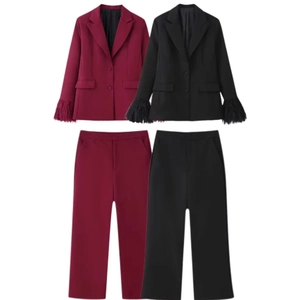 Dettaglio dei polsini piumati su completi eleganti bordeaux e neri da donna slim fit