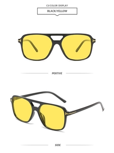Detail view of black square pilot sunglasses with yellow lenses and golden T-shaped hinges
