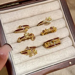 6-piece gold plated ring set with red enamel horse and coin motifs in a jewelry box