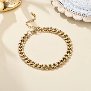 Macro detail of 18K gold Cuban link bracelet with lobster clasp and adjustable tail chain