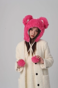 Detail of rose pink plush trapper hat with furry bear ears and soft pompom ties