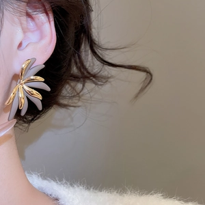 Detail of 18k gold plated flower stud earring with textured two-tone petals on ear