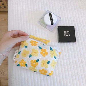 Close-up of floral cotton pouch with yellow flower patterns and zip closure