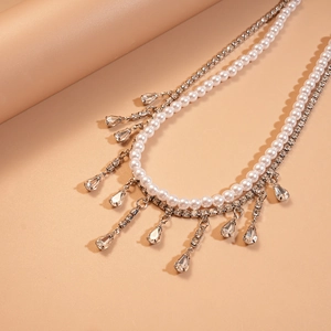 Detailed view of layered necklace featuring white pearls and drop-shaped zircon crystals