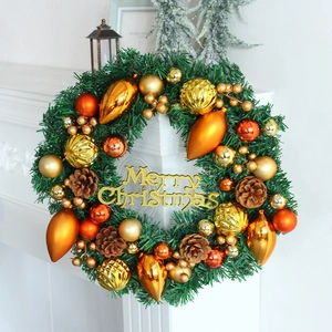 Christmas wreath with pine cones and gold ornaments on a white fireplace mantle